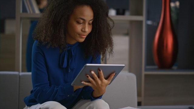 Mulher faz o controle de gastos por meio de aplicativo em seu tablet.
