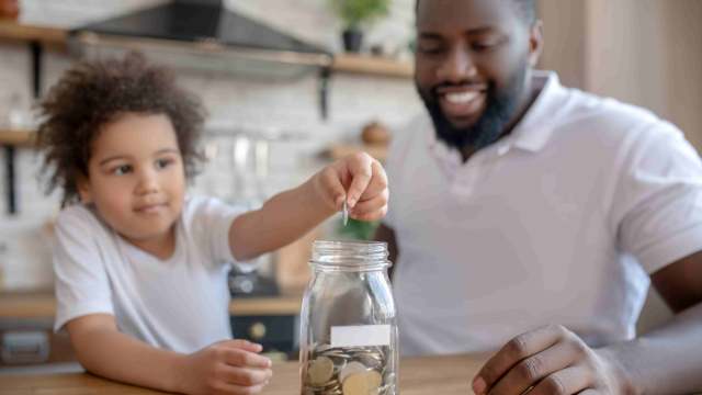 pai acompanha o aprendizado da filha nas aulas de educação financeira escolar