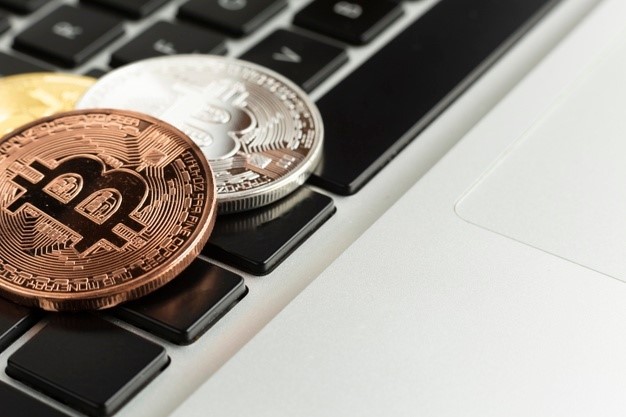 3 moedas bitcoin em cima do teclado do notebook. Ao pesquisar HASH11, entende-se que há na sua composição bitcoin, por isso, a relação com as imagens